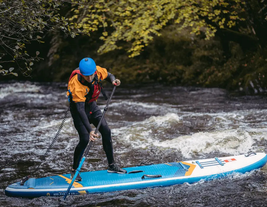 A person paddleboarding in the rapids