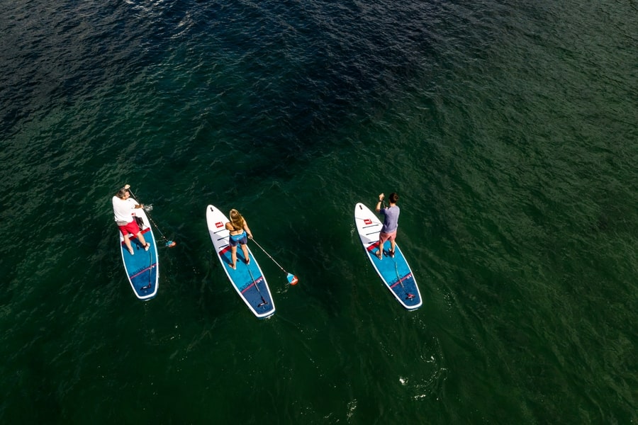 3 people paddle boarding at sea