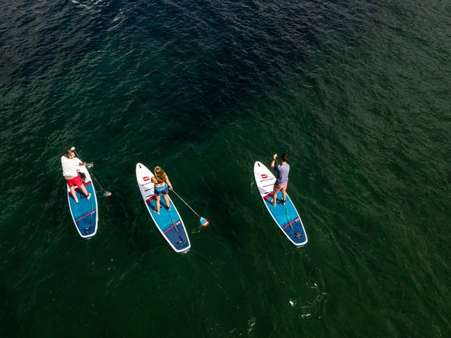3 people paddle boarding at sea