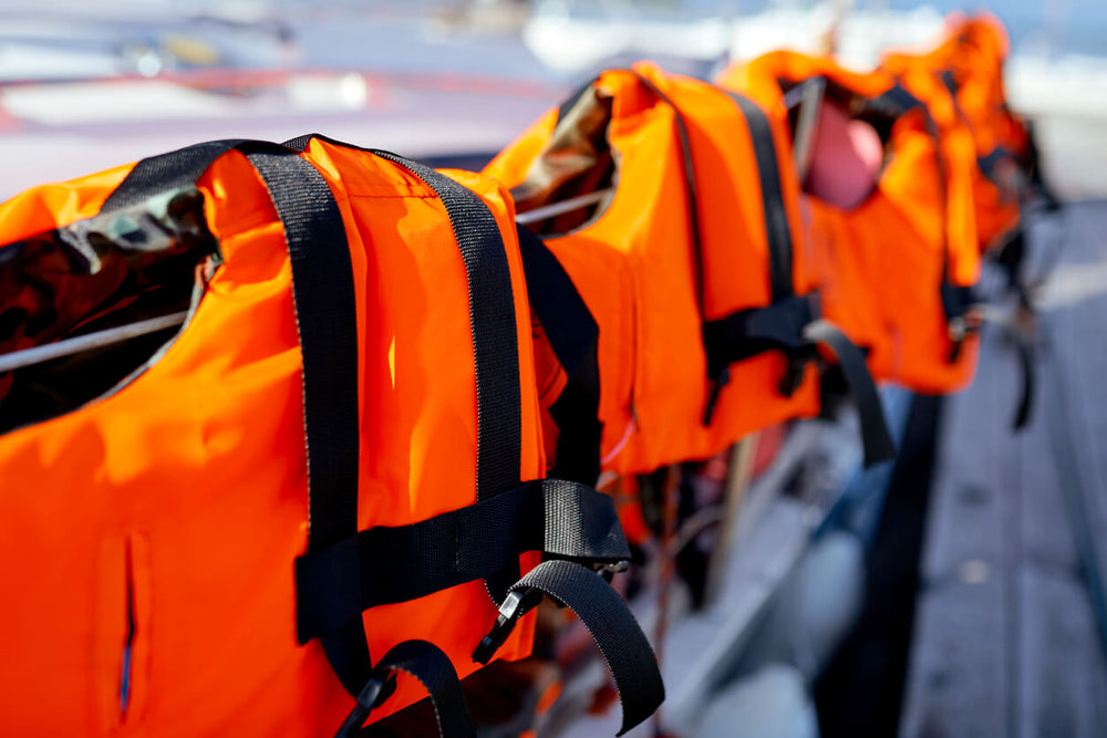 A row of Orange Buoyancy Aids on A Fence