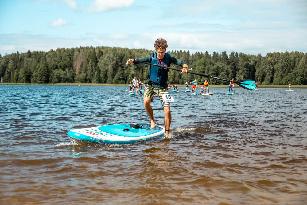 Athlete jumping off A Red Paddle Board