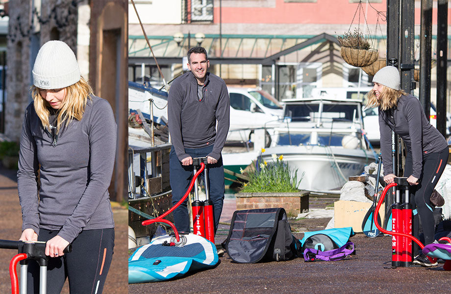 three people pumping up paddleboards