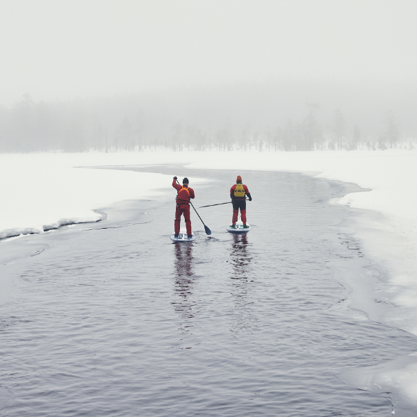 Two people paddling on Red Paddle Co Paddleboard in snow and ice