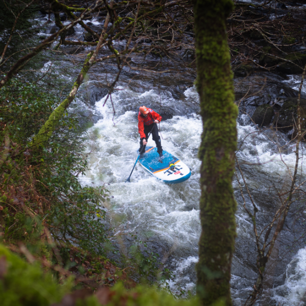 Man paddleboarding Red Paddle Co 9'6" Wild White Water inflatable SUP on river rapids