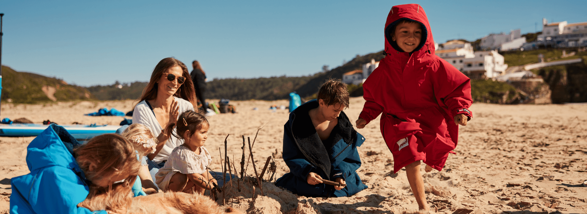 family on the beach with child running towards the camera