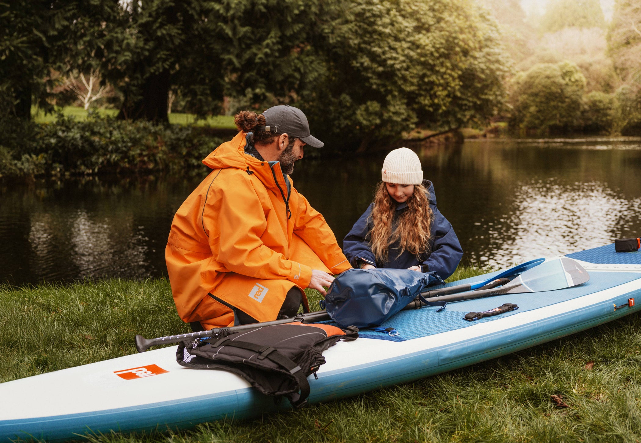 man and daughter packing belongings to use with paddle board