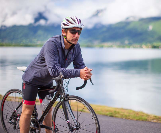 Man sat on bicycle wearing Red Original performance top