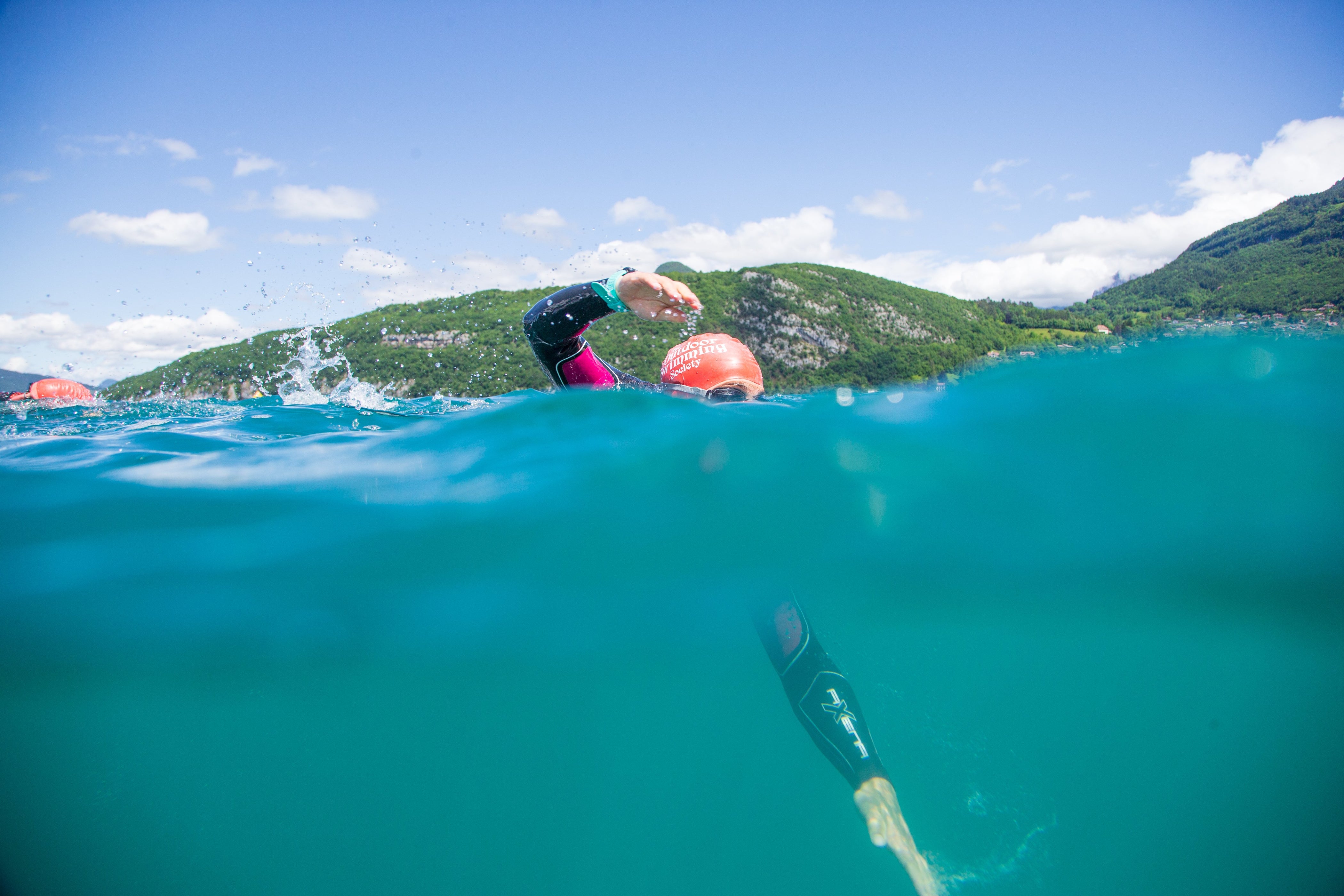 half underwater photo of a man open water swimming