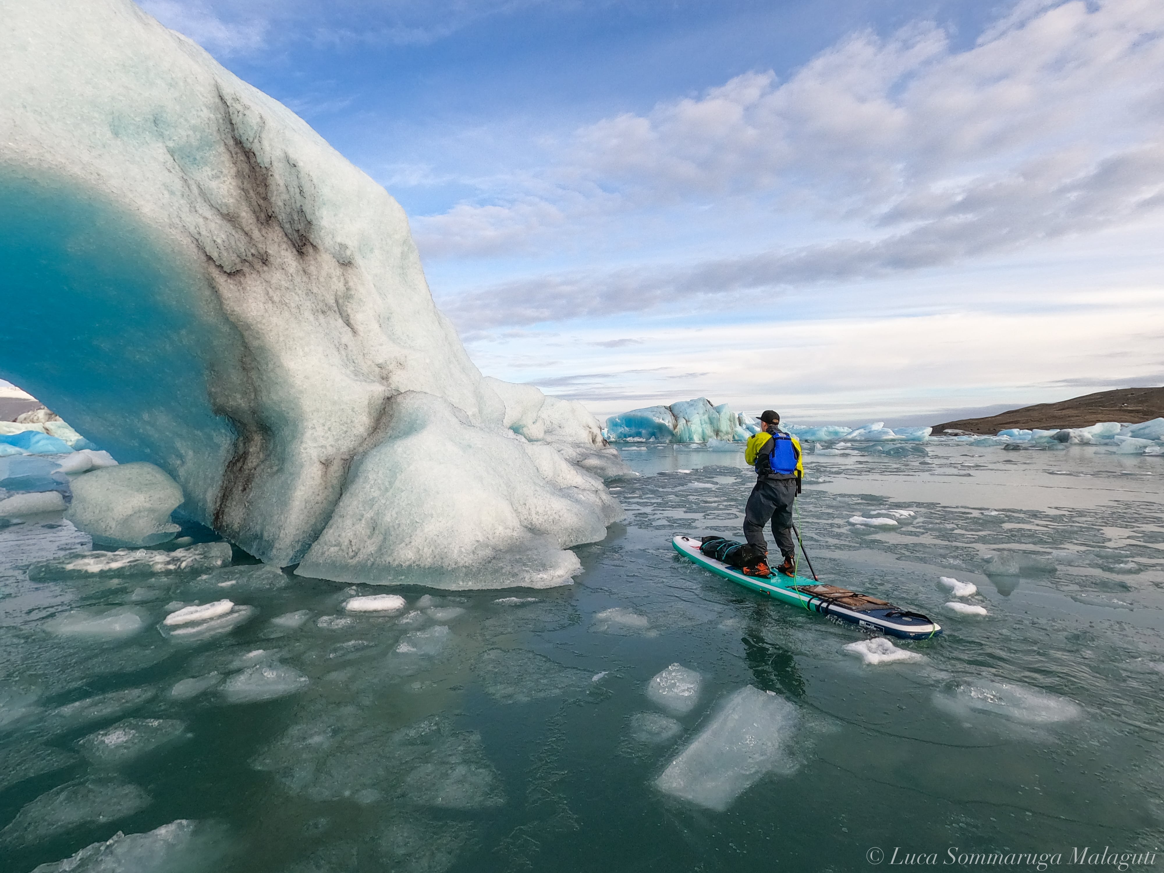 Paddle Boarder In Front Of ice arch