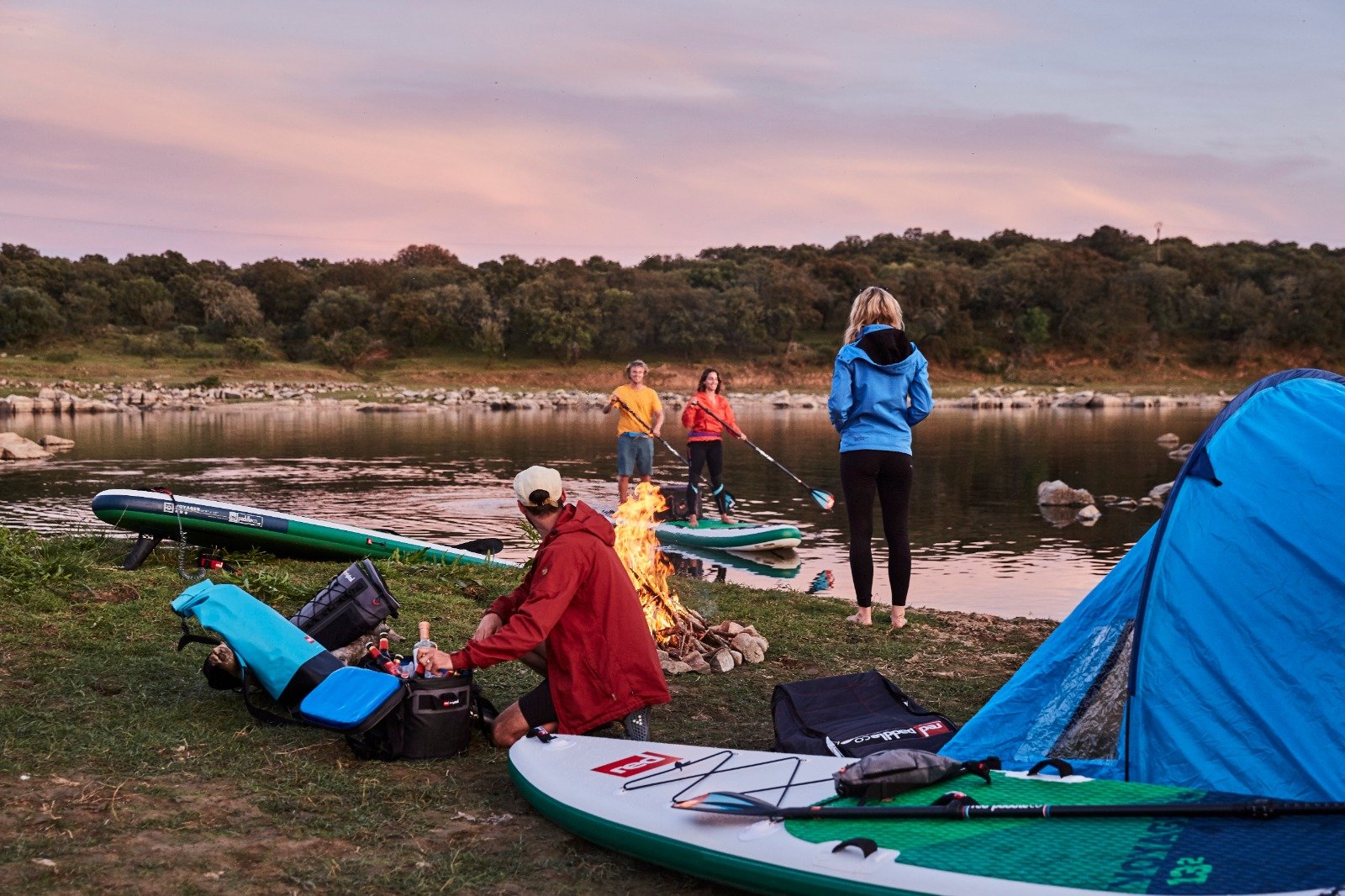 People camping and paddle boarding