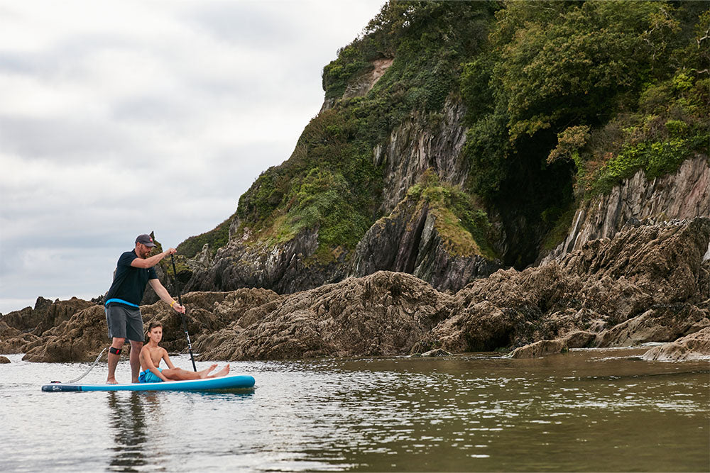 Man and child paddle boarding in the sea