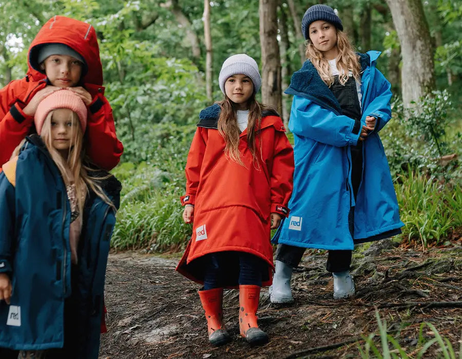 4 children wearing the Red Kids Dry Poncho in the woods