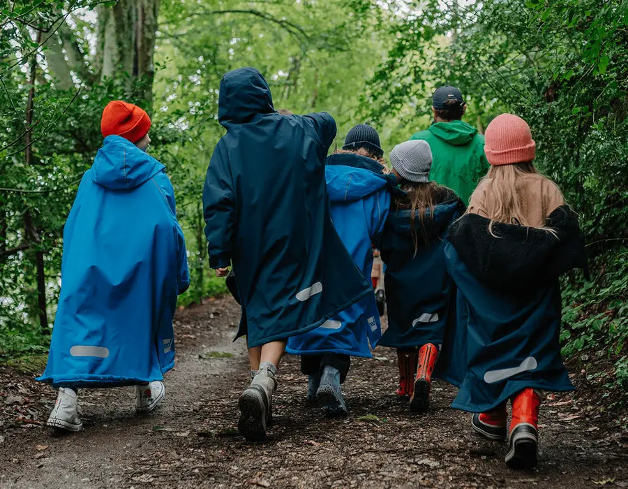 A group of children walking through the woods in their Red Pro Change Robes