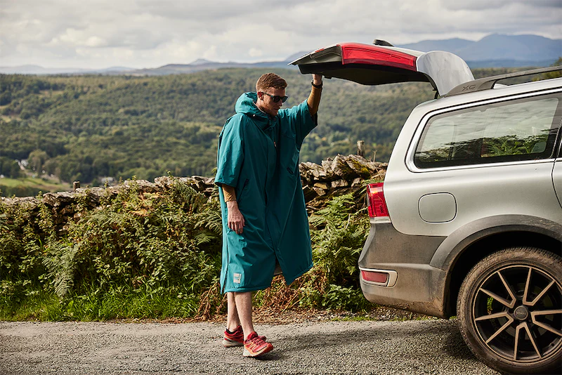 Man wearing Red Original Pro Change Robe closing car boot