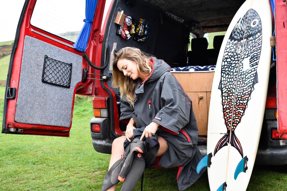 female sitting in camper van wearing change jacket