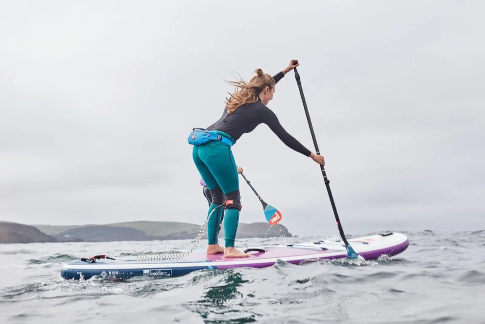 A woman paddling on her paddleboard in the ocean