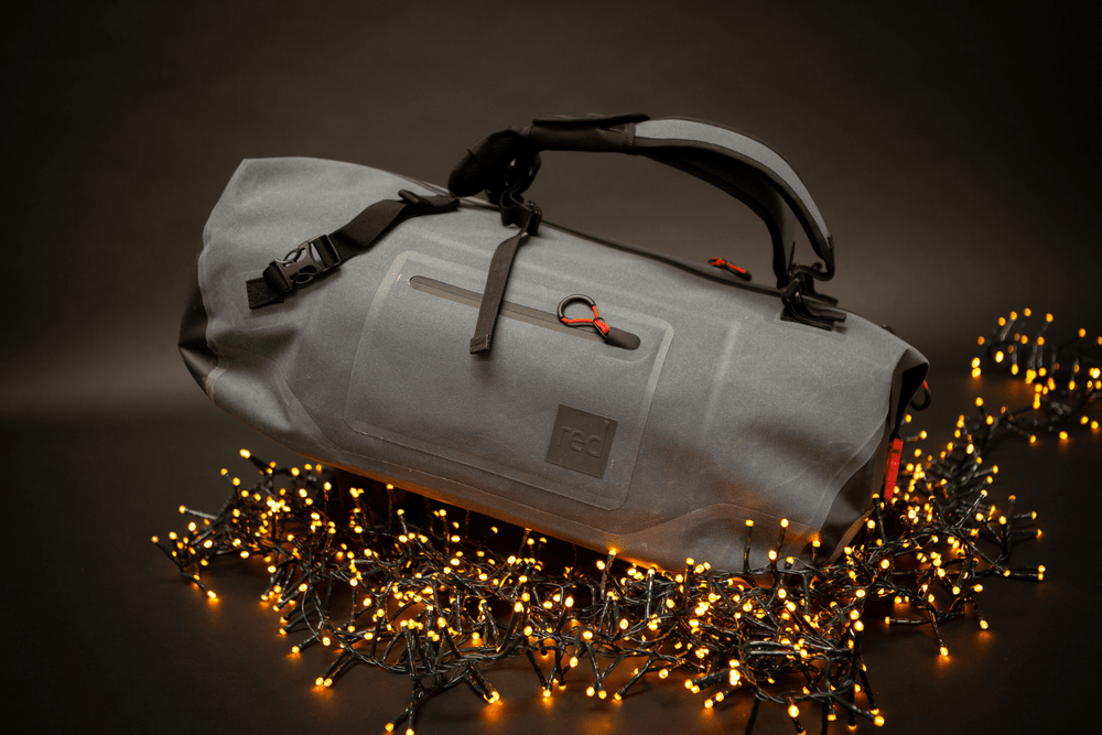 The Red Original Waterproof Kit Bag surrounded by Fairy Lights