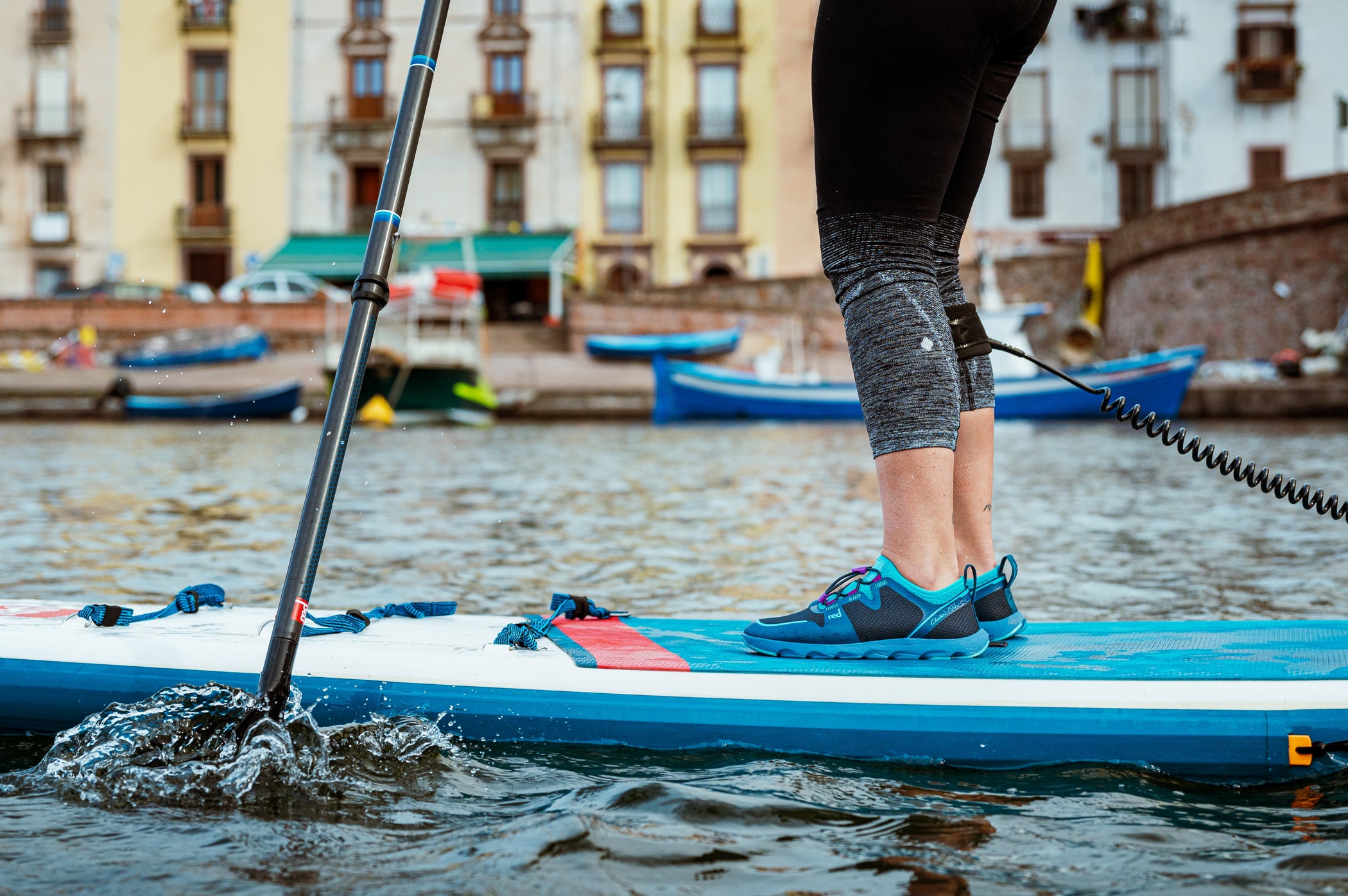 close up of person standing on red paddleboard