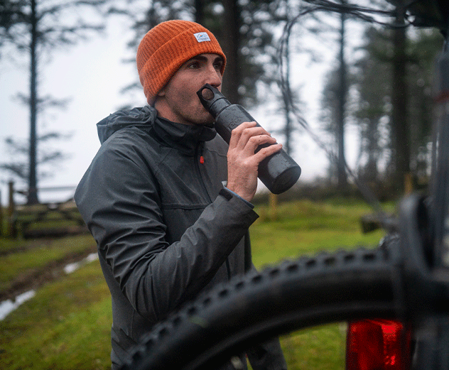 Man drinking from Red Original insulated stainless steel water bottle