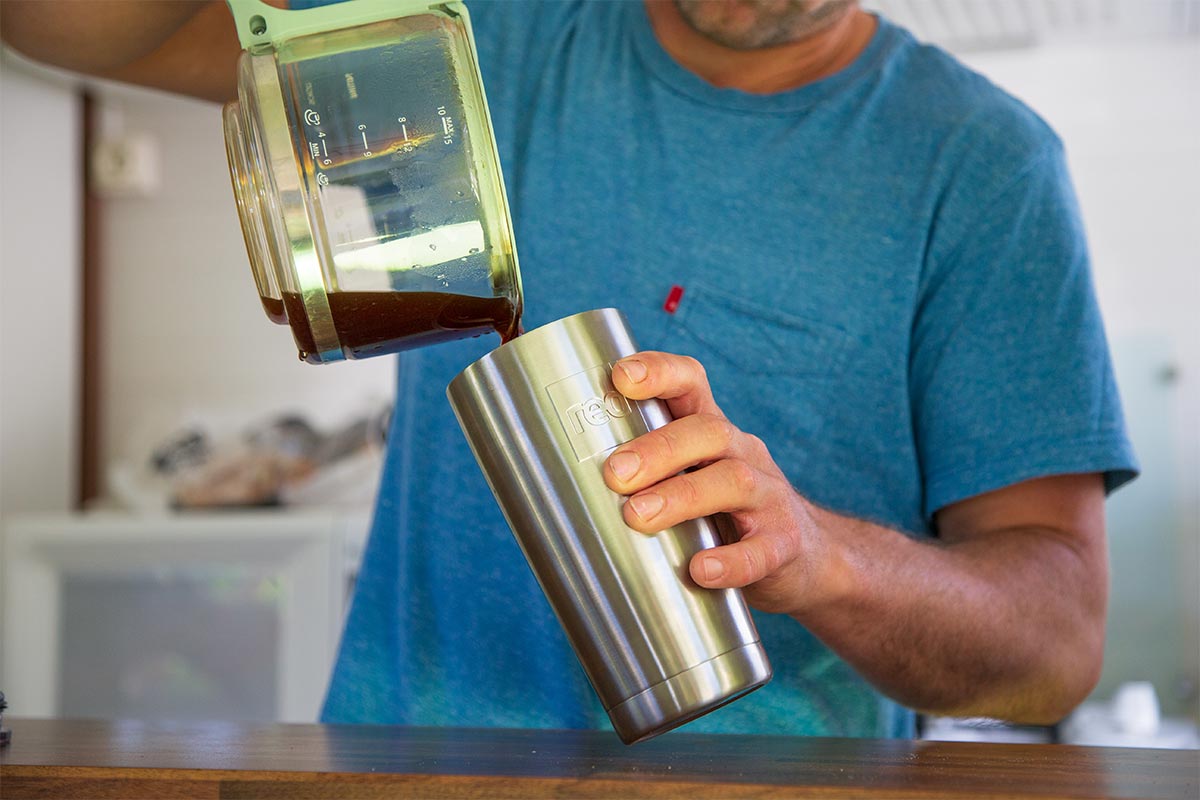 Man pouring coffee into a Red Original Insulated Travel Cup