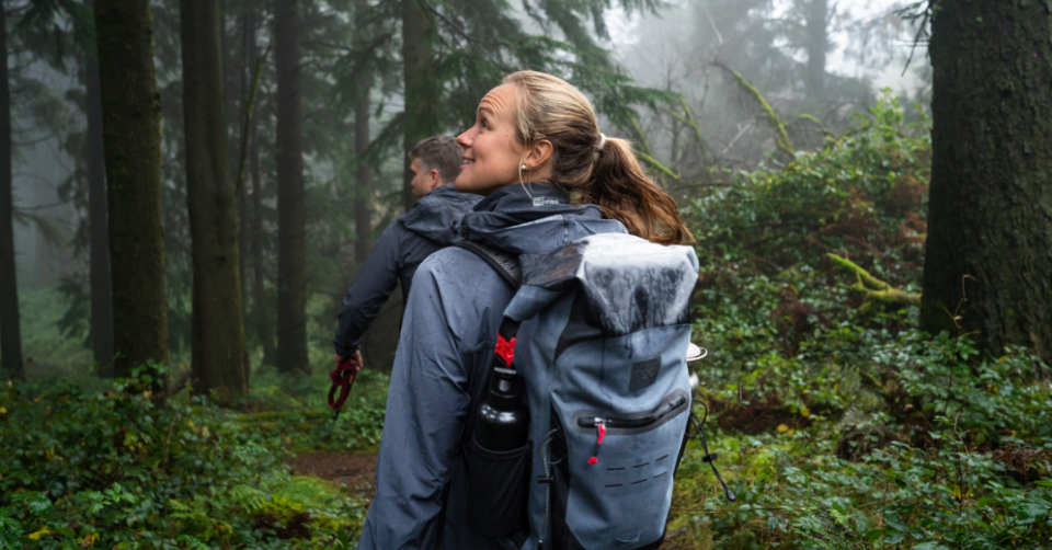 Man and woman hiking in forest wearing Red Original active jackets