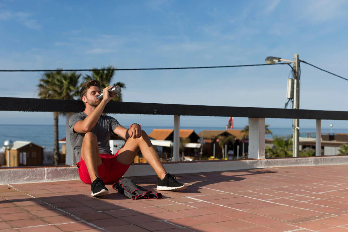 man drinking from water bottle after run