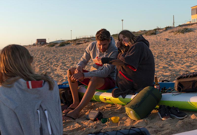 couple sat on paddleboard on the beach