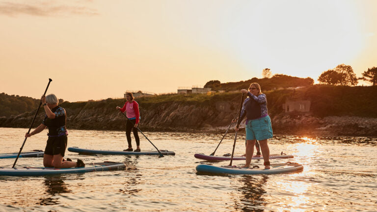 women paddleboarding as a group