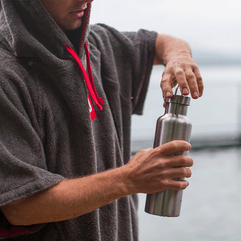 Man wearing Red Original Towelling Change Robe using Insulated Stainless Steel Water Bottle next to Lake Annecy