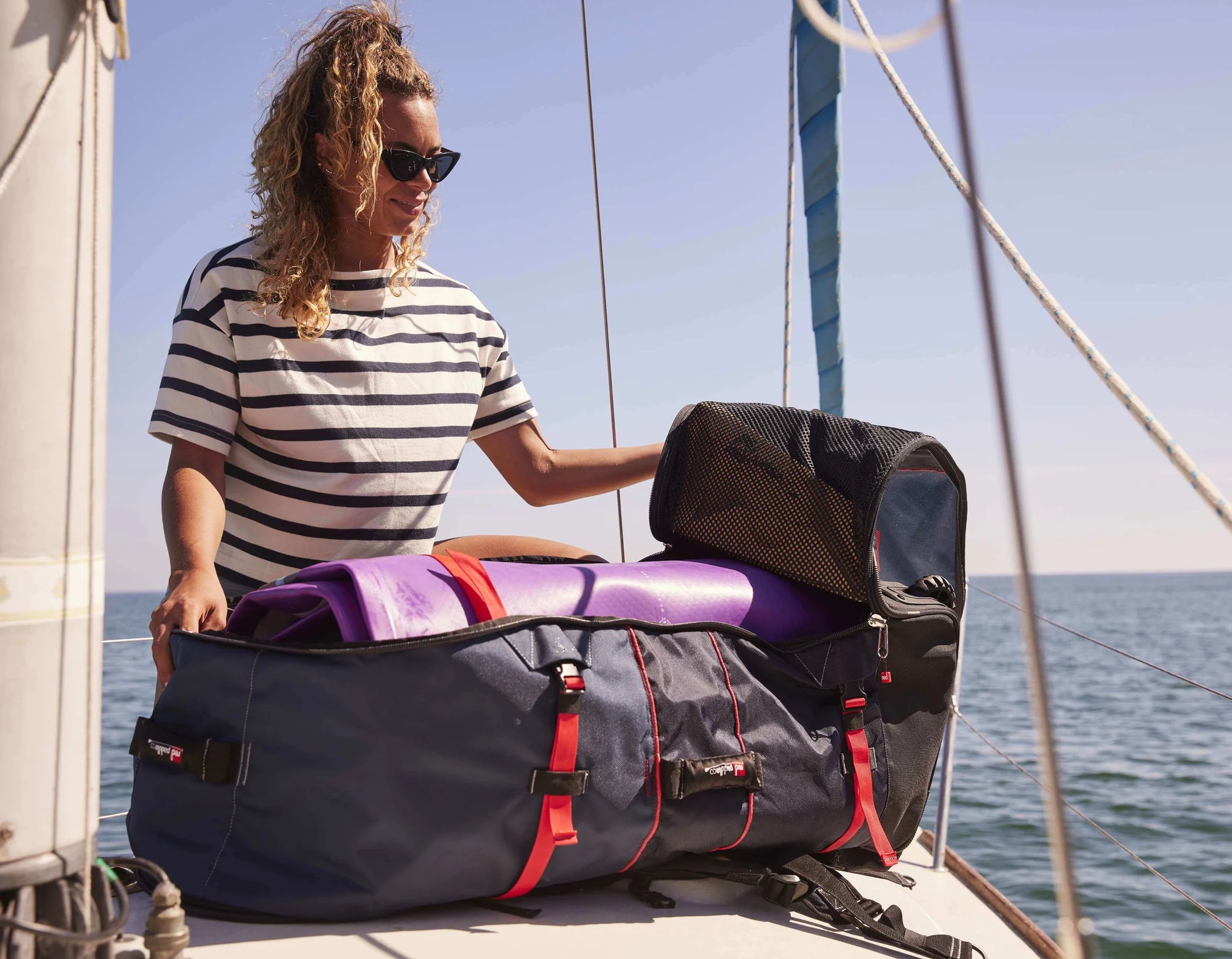 A woman unpacking her inflatable paddleboard on a boat
